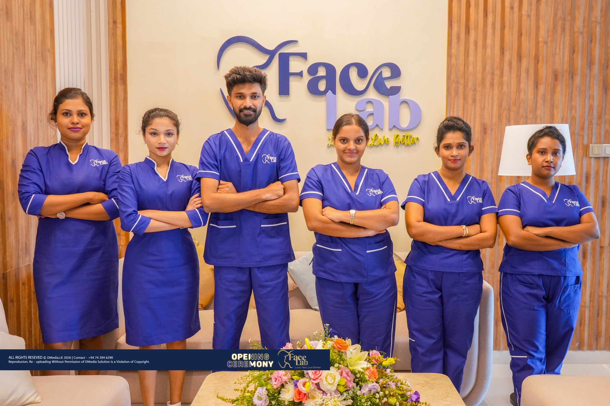 FaceLab clinical staff in scrubs gathered in front of the brand wall